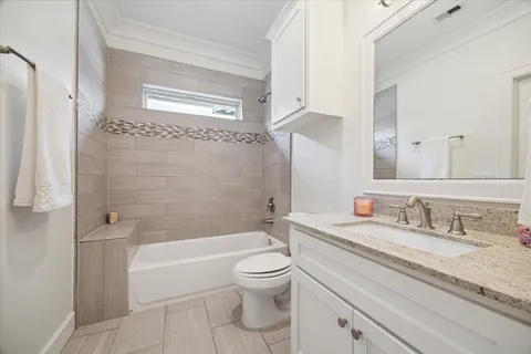 a bathroom with a granite countertop toilet a sink and a bathtub