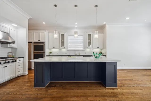 a large kitchen with kitchen island a sink stainless steel appliances and cabinets