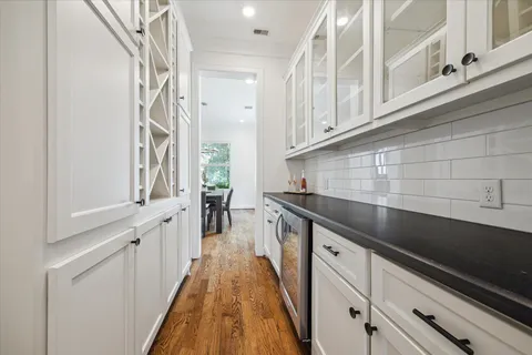 a kitchen with granite countertop white cabinets and white appliances