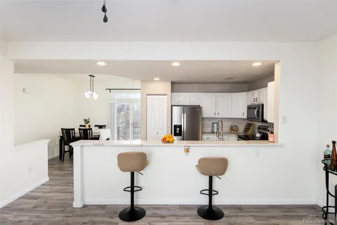 a kitchen with stainless steel appliances kitchen island granite countertop a sink and a refrigerator