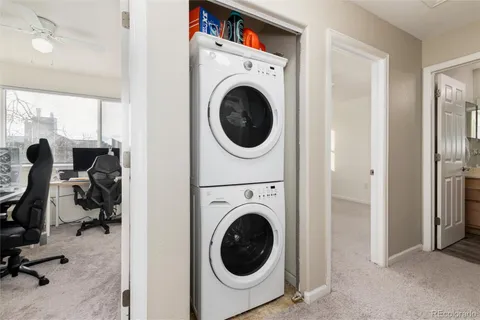 a utility room with dryer washer and a view of living room
