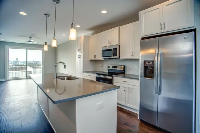 a kitchen with kitchen island a refrigerator stove microwave and sink