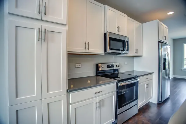 a kitchen with stainless steel appliances granite countertop a stove a microwave and a refrigerator