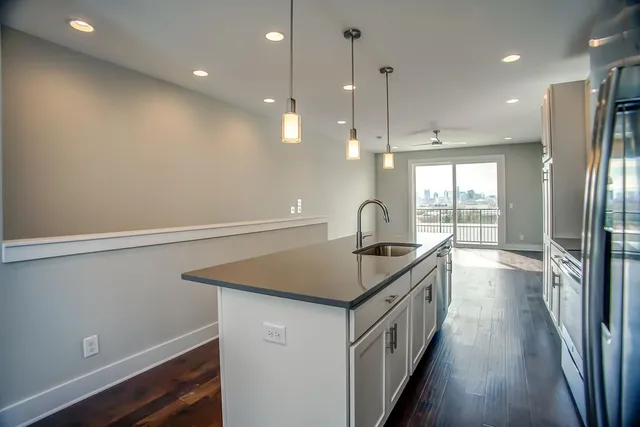 a kitchen that has a lot of cabinets and wooden floor