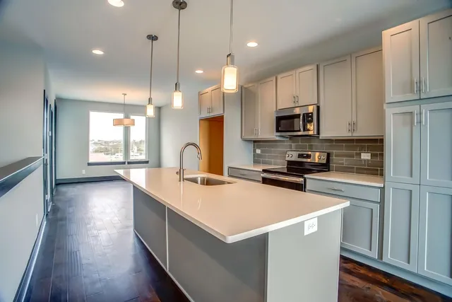 a kitchen that has a lot of cabinets and wooden floor