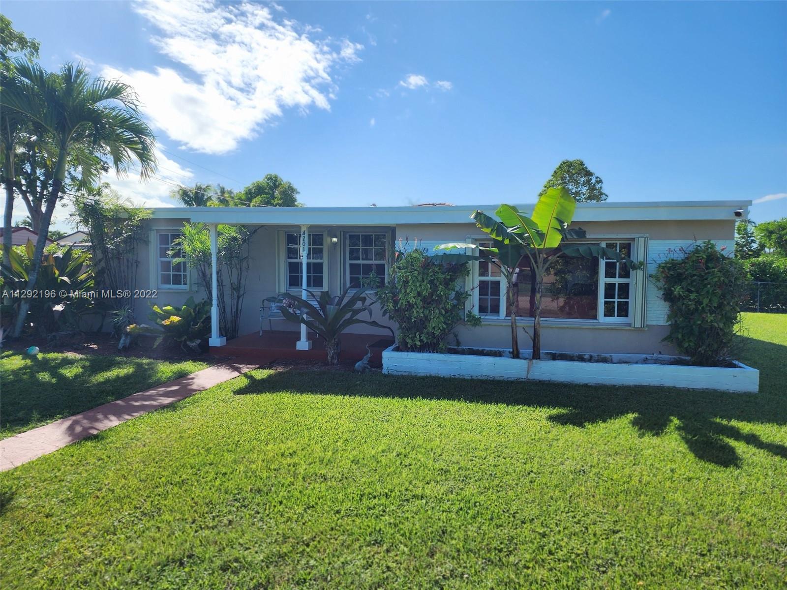 a view of a house with a yard and potted plants