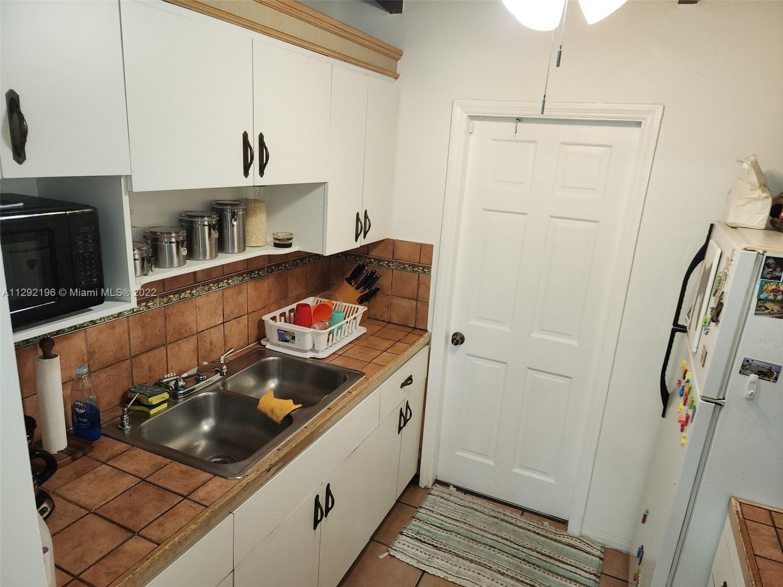 Tropical Estates Miami, FL 33165 - Photo 13 of 31 a kitchen with a sink and cabinets