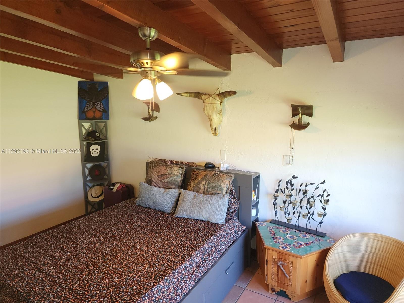 Tropical Estates Miami, FL 33165 - Photo 14 of 31 a bed room with a bed and a chandelier