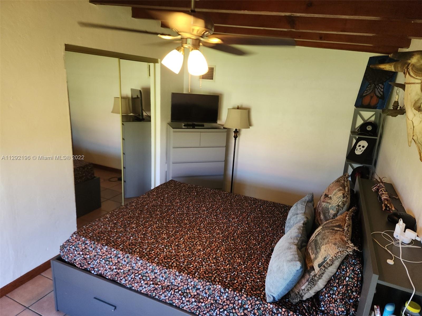 Tropical Estates Miami, FL 33165 - Photo 15 of 31 a bedroom with a bed and a flat tv screen on the dresser