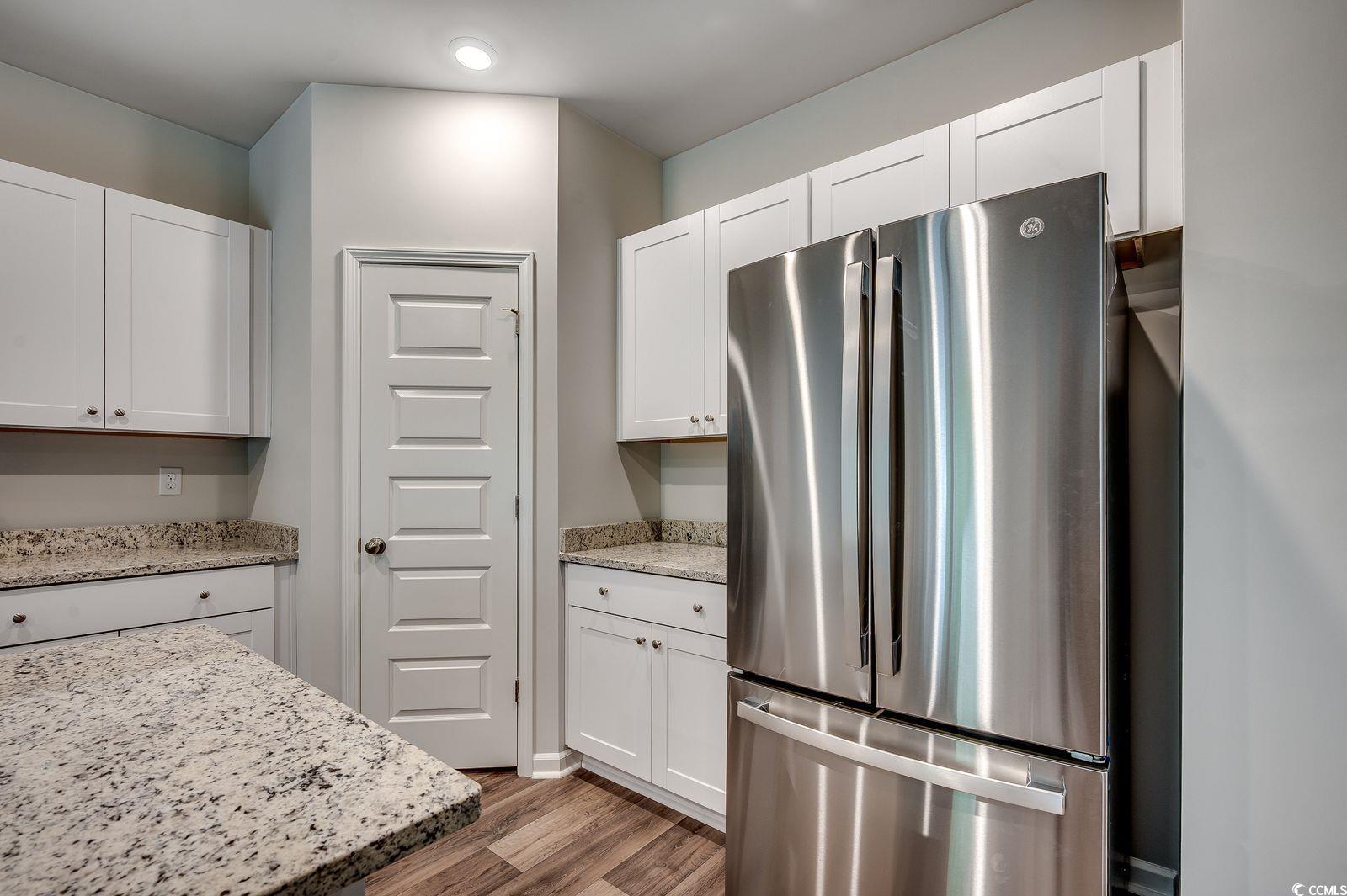 1004 Sentinel Court Little River, SC 29566 - Photo 7 of 31 Kitchen featuring freestanding refrigerator, wood finished floors, and white cabinets