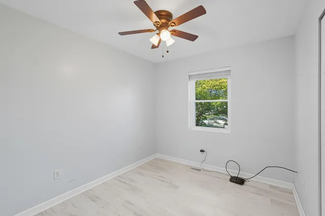 a view of a room with a window and a ceiling fan