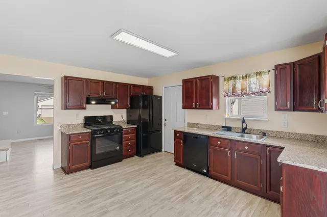 a kitchen with stainless steel appliances granite countertop a sink dishwasher stove and refrigerator