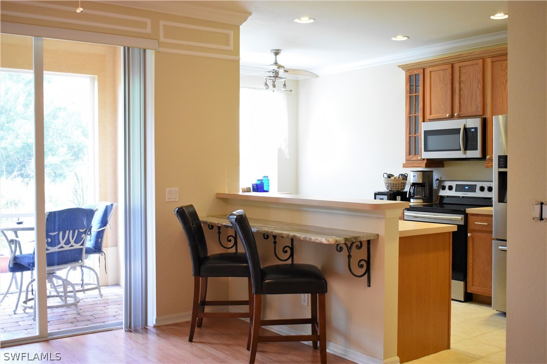 4002 Cherrybrook Loop Fort Myers, FL 33966 - Photo 3 of 35 a kitchen with stainless steel appliances granite countertop a table chairs and a refrigerator