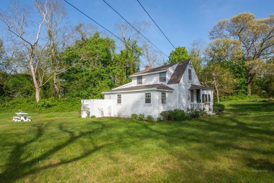 50 Mill Road Eastham, MA 02642 - Photo 20 of 26 a view of a house with a big yard potted plants and large tree