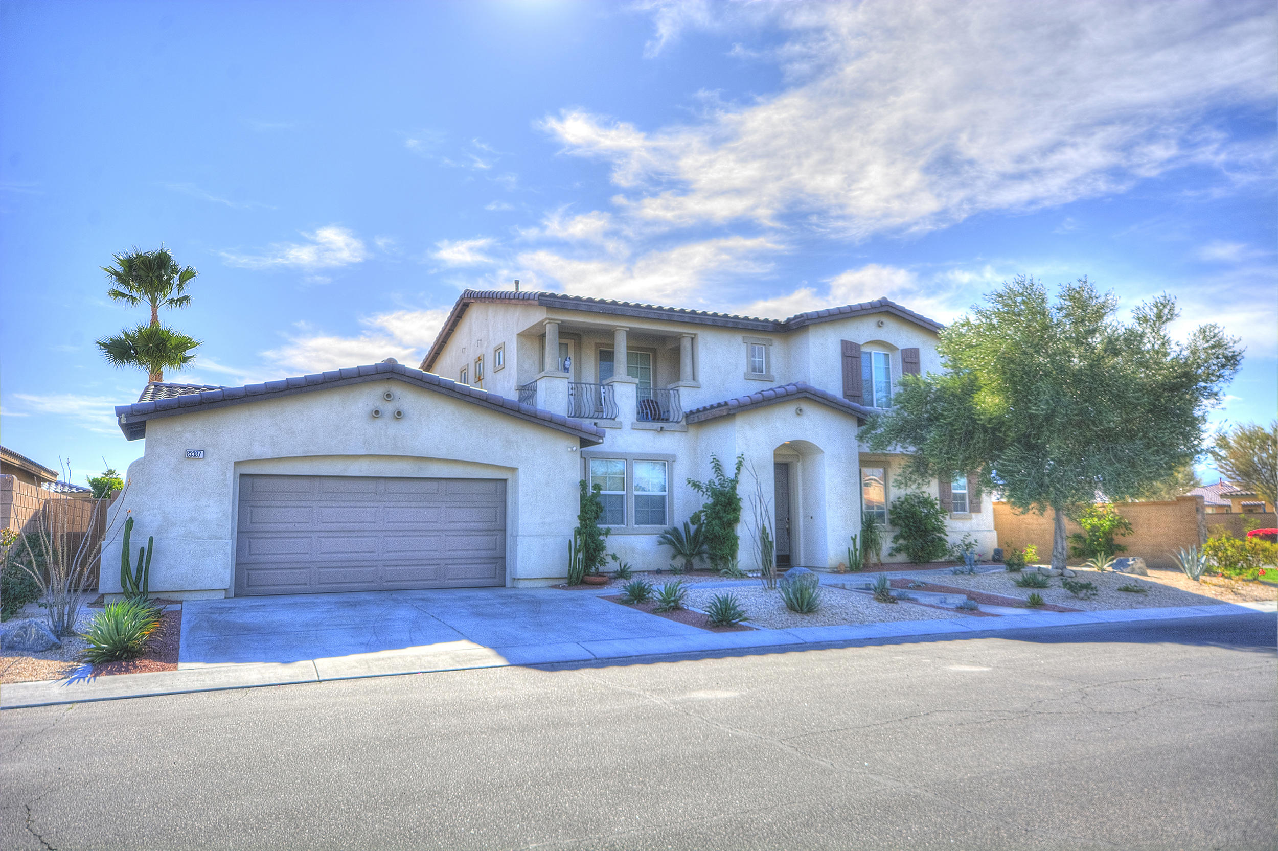 83387 Lightning Road Indio, CA 92203 - Photo 1 of 20 a front view of a house with a yard and garage