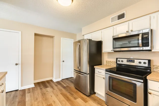 a kitchen with stainless steel appliances a refrigerator stove and microwave