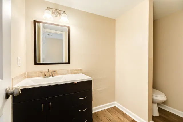 a bathroom with a toilet sink and mirror