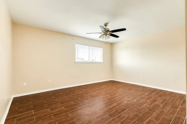a view of a big room with wooden floor and windows in a room