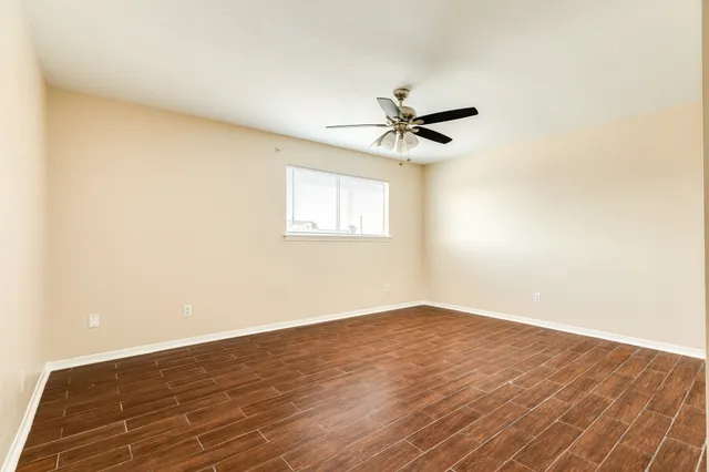 a view of a big room with wooden floor and windows in a room