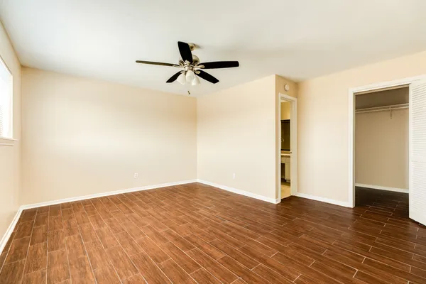 a view of empty room with wooden floor