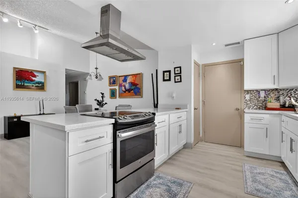 a kitchen with stainless steel appliances granite countertop a stove a sink and a refrigerator