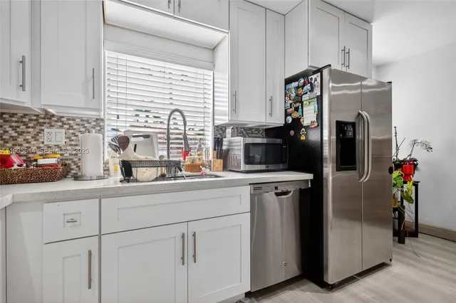 a kitchen with stainless steel appliances a refrigerator sink and cabinets