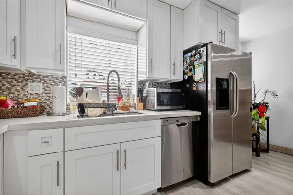 a kitchen with stainless steel appliances a refrigerator sink and cabinets
