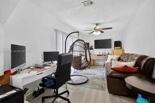 a workspace with furniture and a chandelier fan