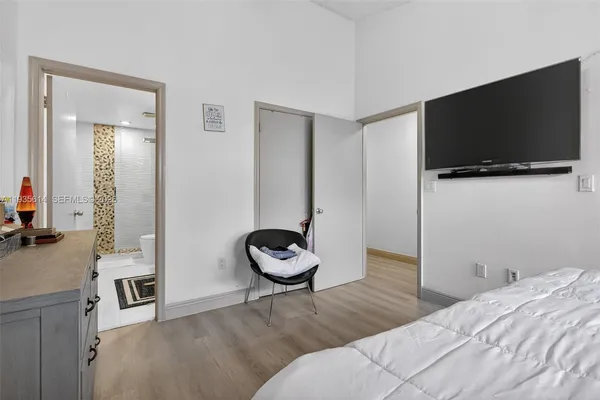 a bedroom with a bed and a flat screen tv