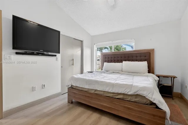 a bedroom with a bed and a flat screen tv