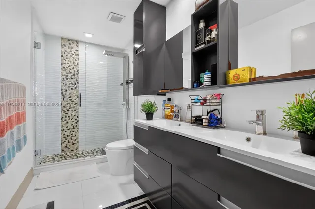 a bathroom with a sink a toilet and shower