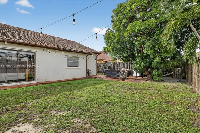 a view of backyard with wooden fence