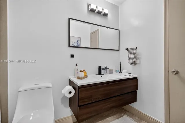 a white bathroom with a sink mirror and vanity