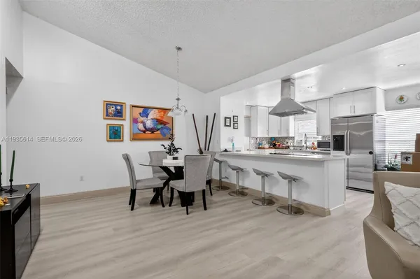 a living room with stainless steel appliances kitchen island furniture and a wooden floor