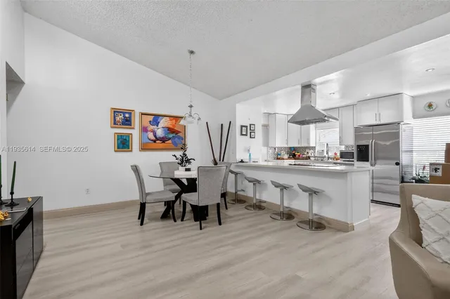 a living room with stainless steel appliances kitchen island furniture and a wooden floor
