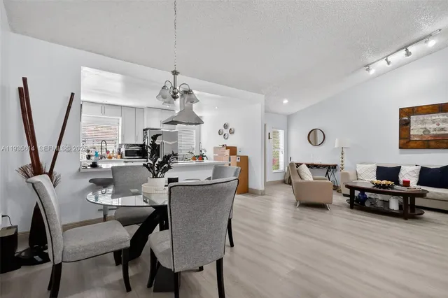 a view of a dining room with furniture a rug and wooden floor