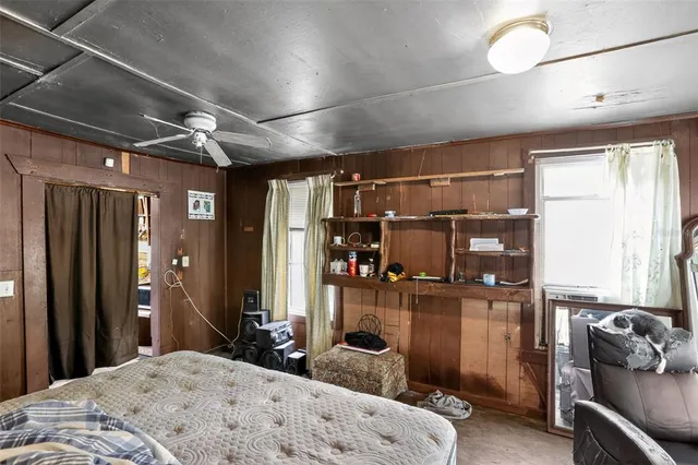 a bedroom with a bed a flat screen tv and dresser