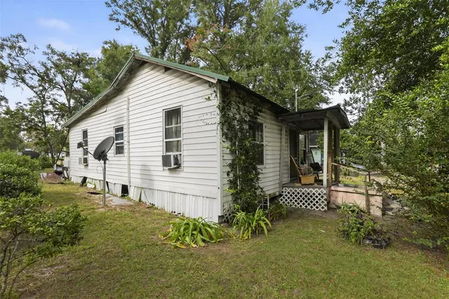 a view of backyard of house with wooden fence