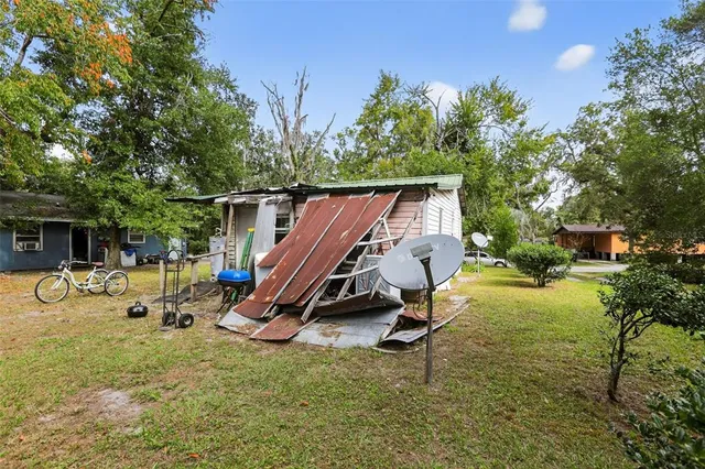 a view of a backyard with chairs and a tree