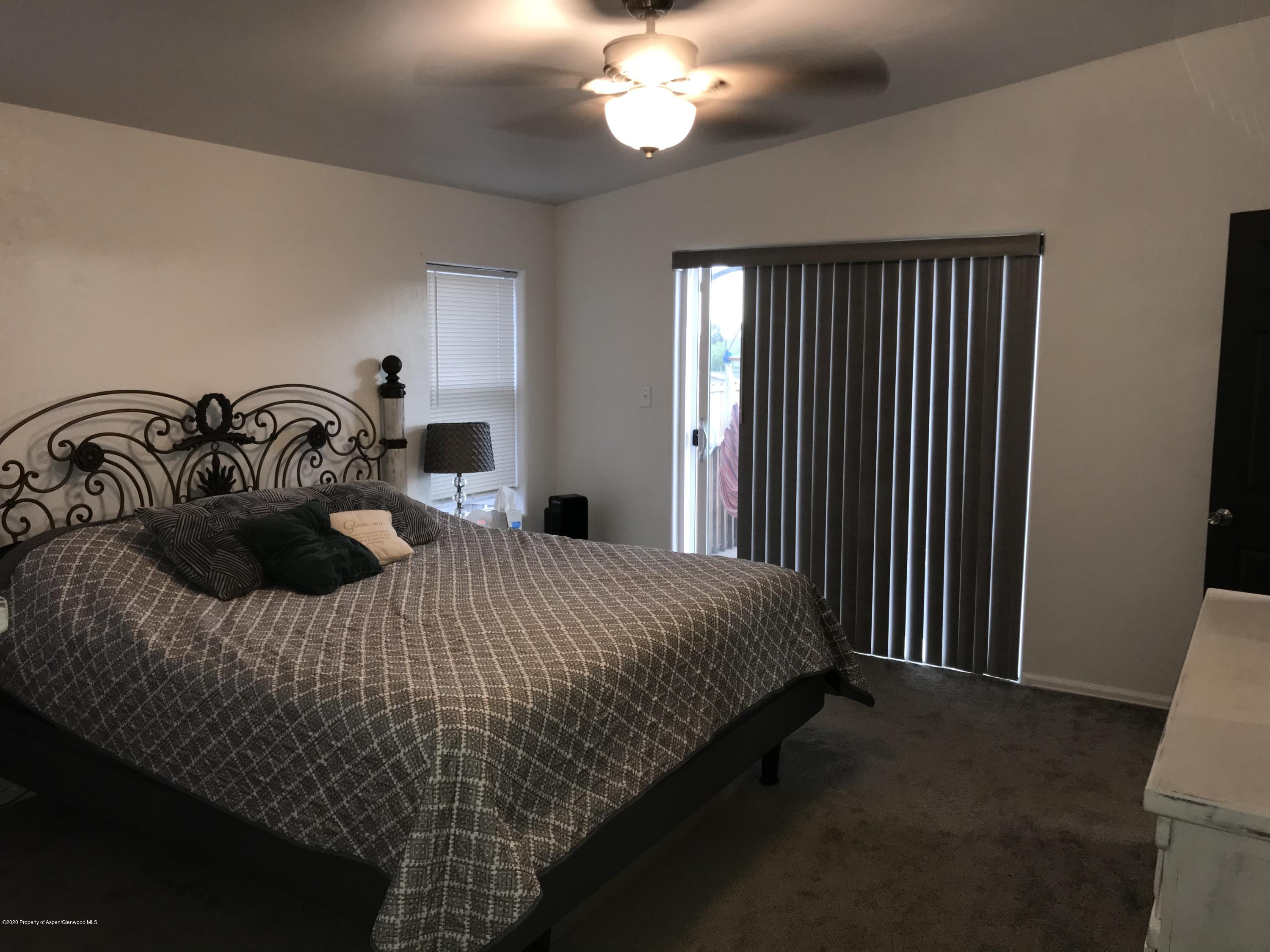 106 Cedar Circle Parachute, CO 81635 - Photo 11 of 22 a bedroom with a bed and a chandelier