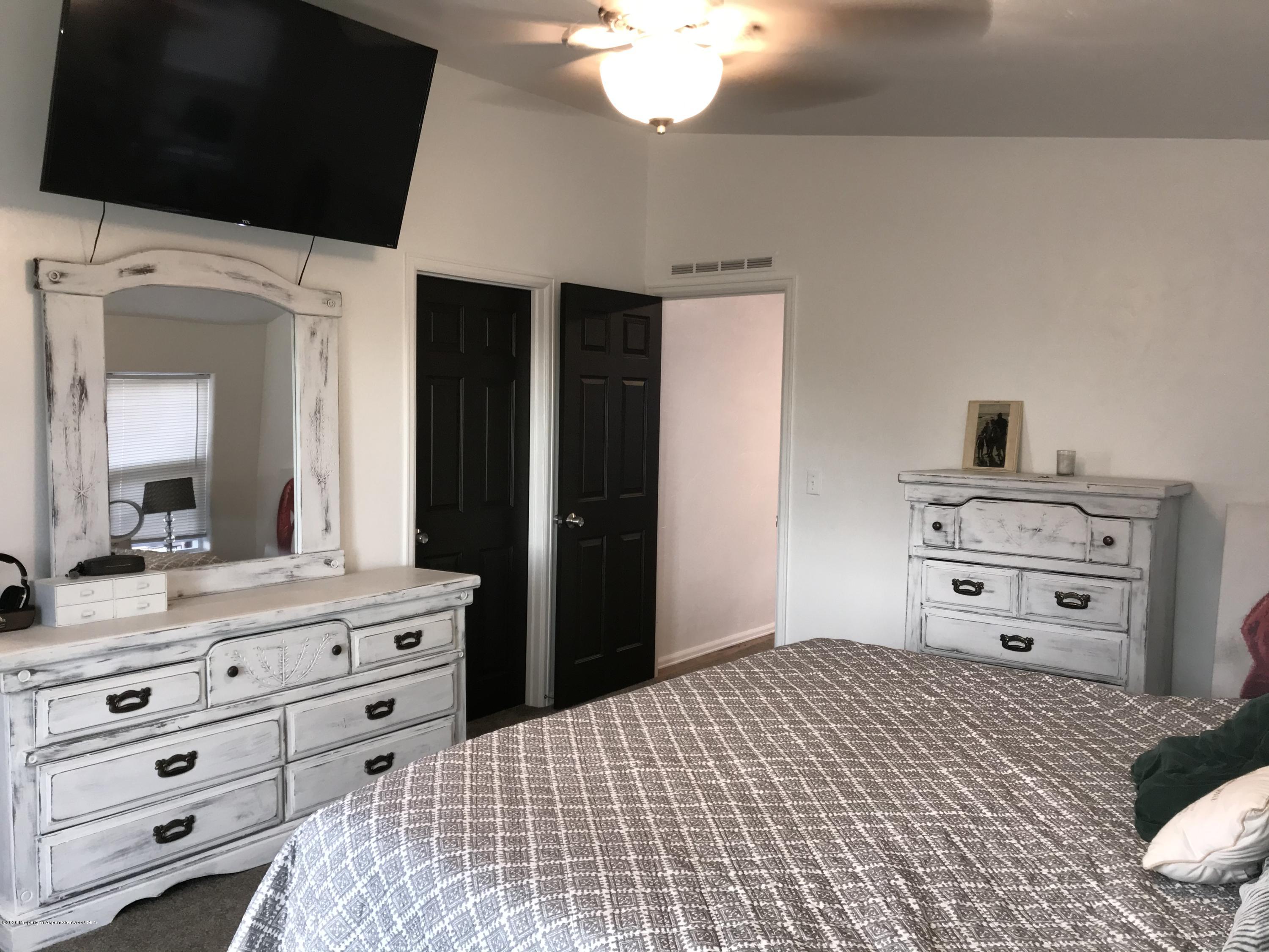 106 Cedar Circle Parachute, CO 81635 - Photo 12 of 22 a bedroom with a bed and a flat tv screen on dresser