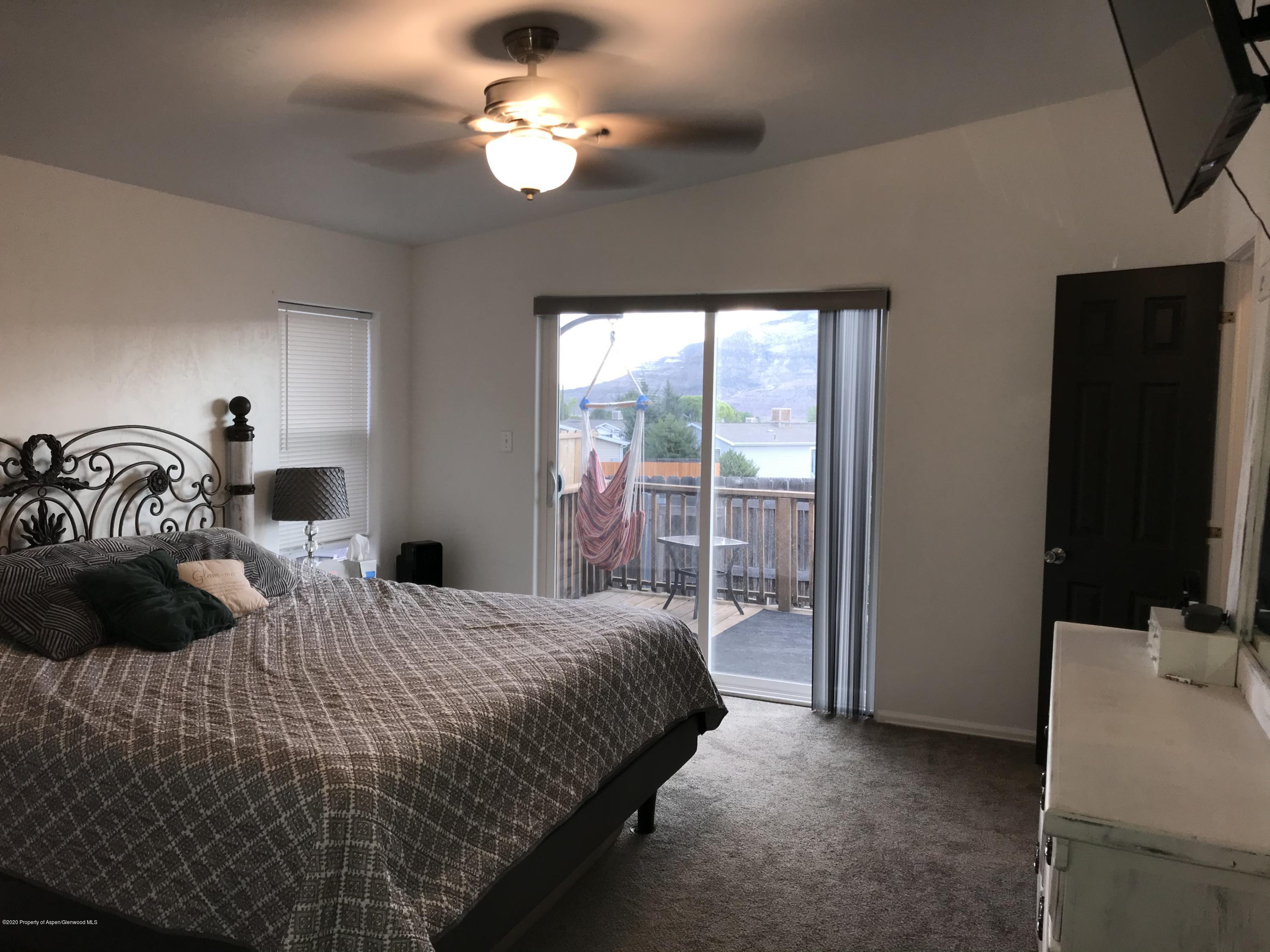 106 Cedar Circle Parachute, CO 81635 - Photo 13 of 22 a bedroom with a bed a dresser and a flat tv screen