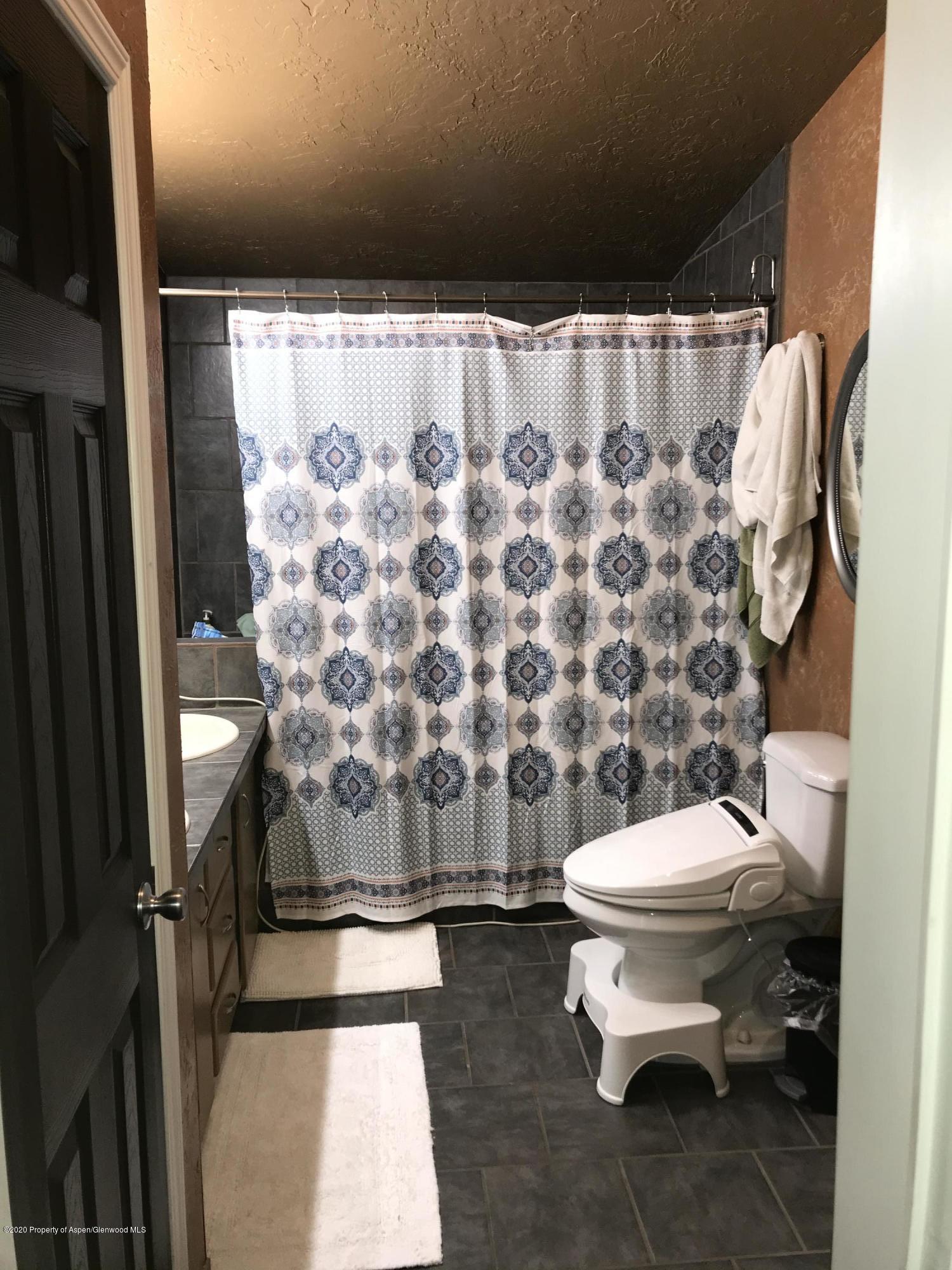 106 Cedar Circle Parachute, CO 81635 - Photo 14 of 22 a white toilet sitting next to a shower curtain