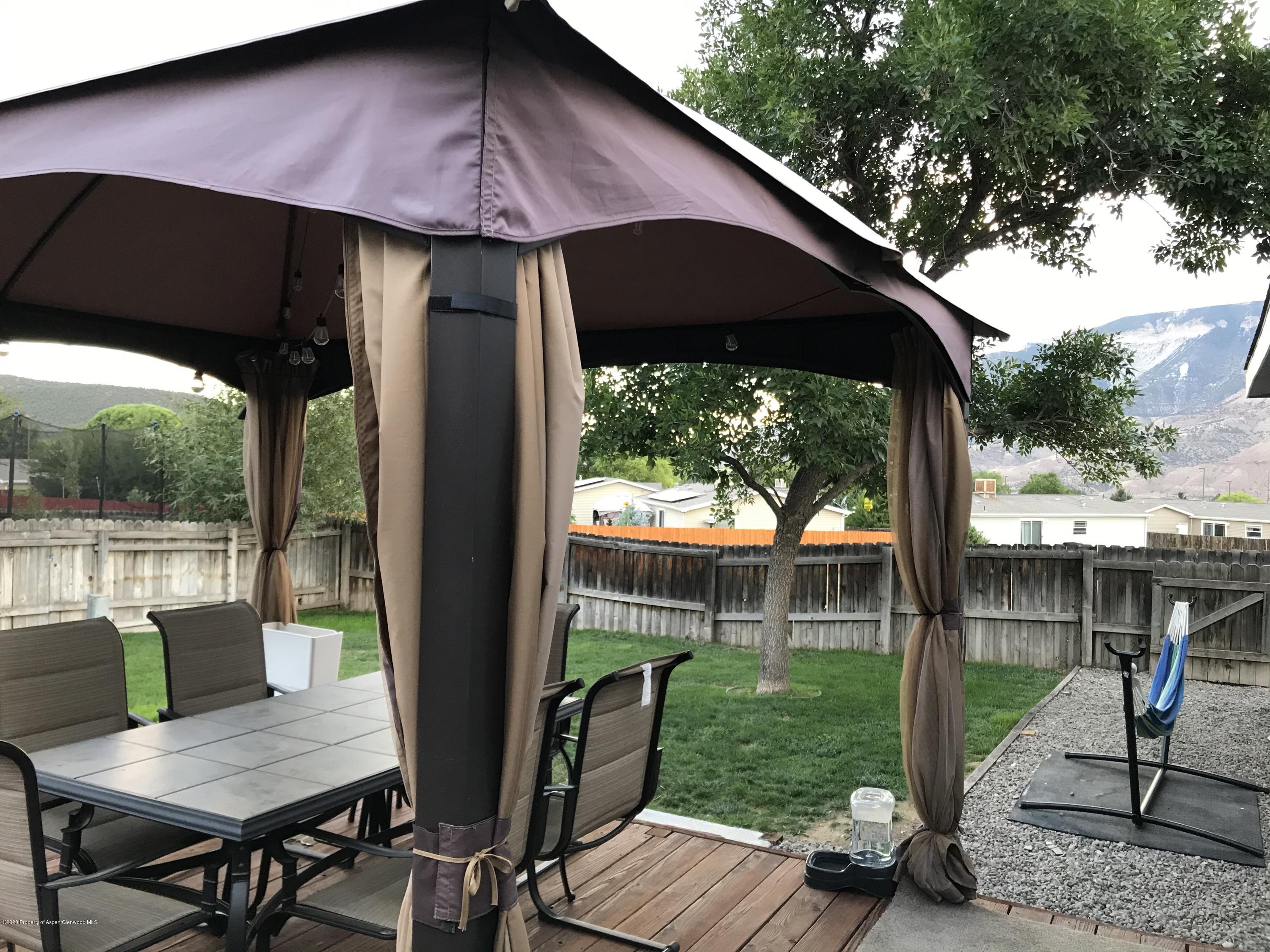 106 Cedar Circle Parachute, CO 81635 - Photo 18 of 22 a view of a patio with table and chairs under an umbrella