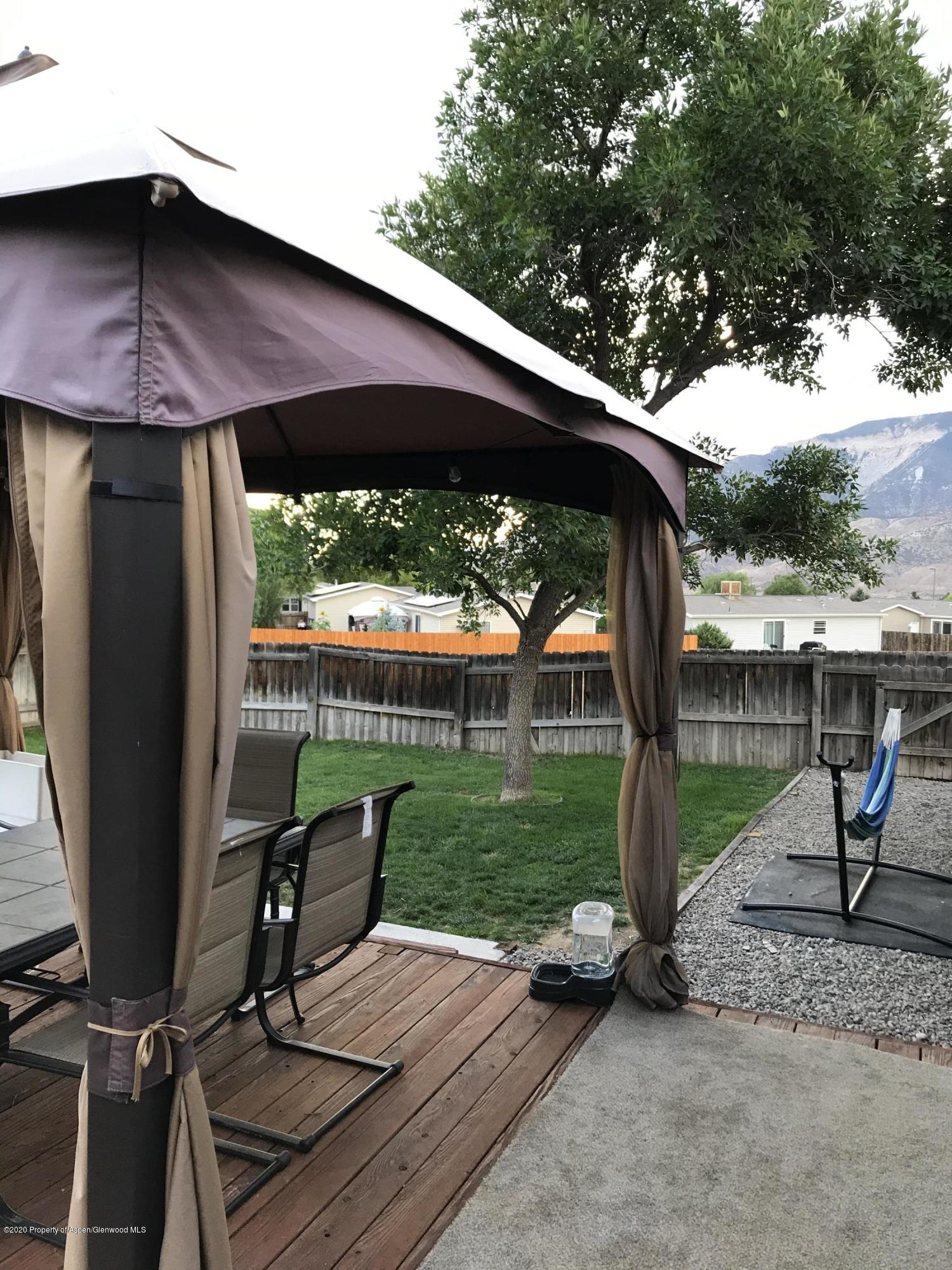 106 Cedar Circle Parachute, CO 81635 - Photo 19 of 22 a view of a deck with a table and chairs under an umbrella