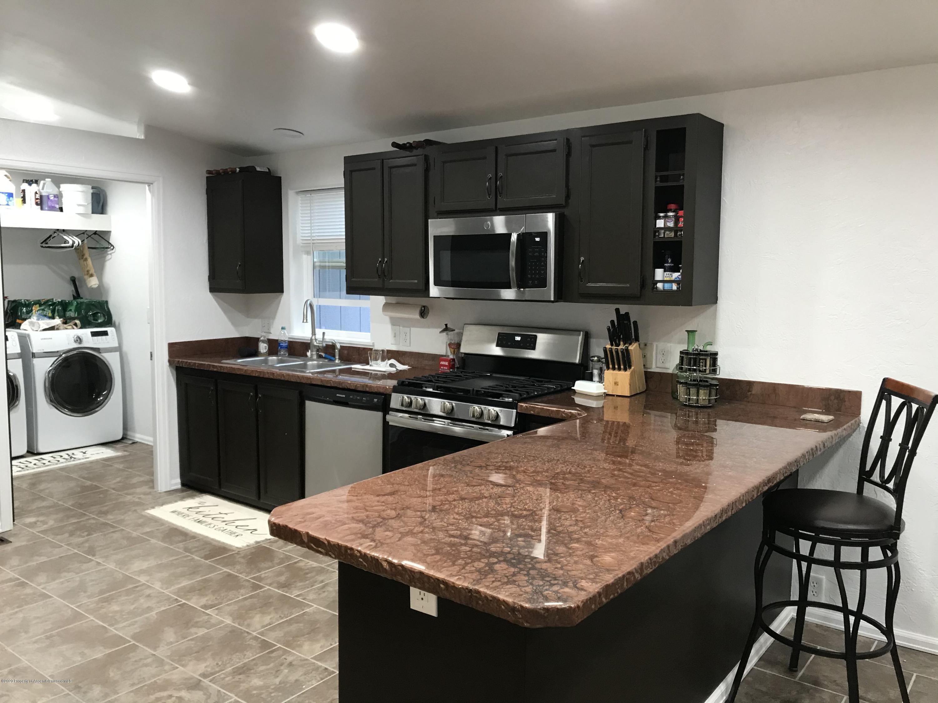 106 Cedar Circle Parachute, CO 81635 - Photo 6 of 22 a kitchen with a stove a sink a microwave and a refrigerator