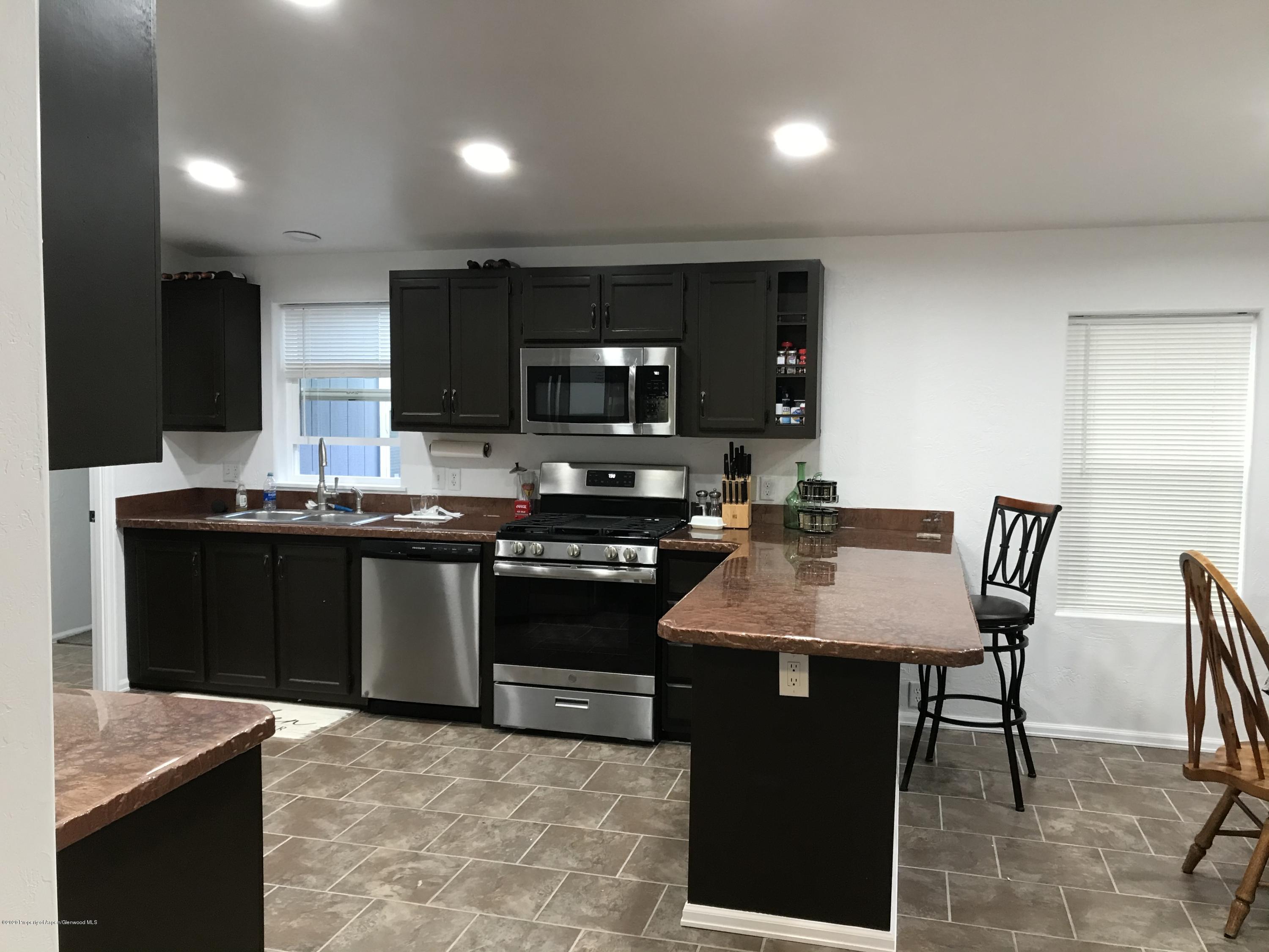 106 Cedar Circle Parachute, CO 81635 - Photo 7 of 22 a kitchen with stainless steel appliances granite countertop a stove a sink a microwave a dining table and chairs