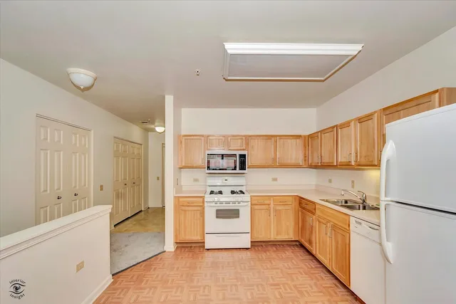 a kitchen with white cabinets and white appliances
