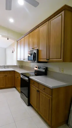 a kitchen with stainless steel appliances granite countertop a sink a stove top oven a counter space and cabinets