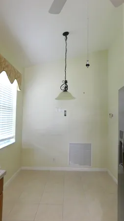 a view of a livingroom with a chandelier curtains and large windows